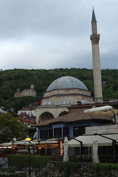 Free A serene view of a historic mosque and minaret against a lush hillside backdrop, perfect for cultural travel themes. Stock Photo