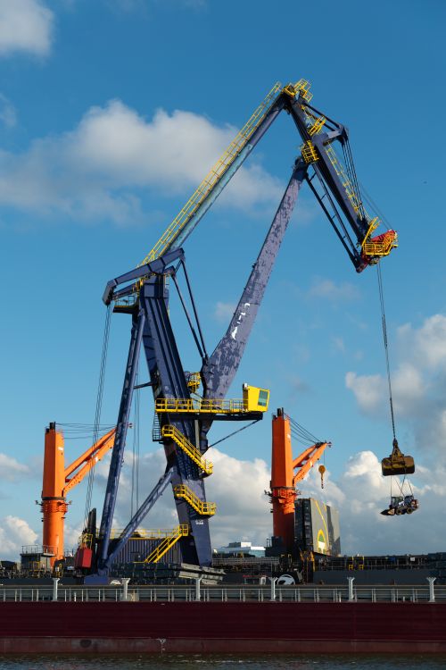 Free A large industrial crane operating at Rotterdam port, Netherlands on a clear day. Stock Photo