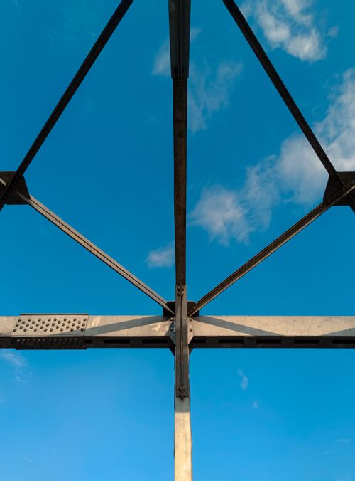 Free View of a steel structure against a blue sky with clouds. Stock Photo