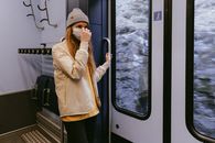 一名戴着口罩的妇女在通勤的火车上，遵守着安全规程