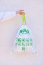 Person Holding White and Green Plastic Bag