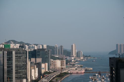 Free Aerial view of a bustling city harbor with modern skyscrapers and a lively waterfront. Stock Photo