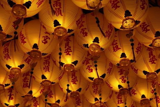 Glowing lanterns with Chinese characters create a warm ambiance at a Taiwanese temple festival.