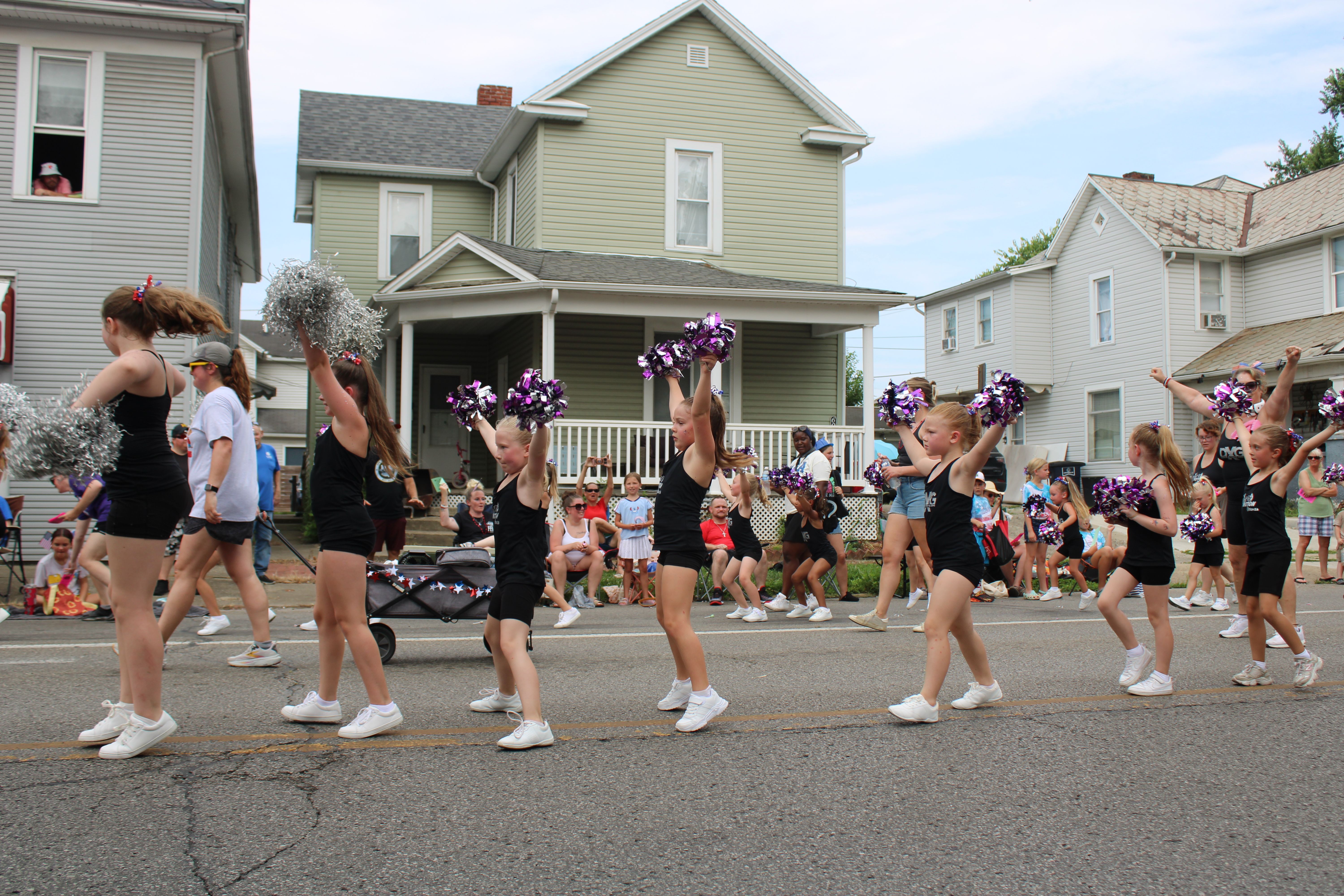 Young cheerleaders with pom-poms perform at a lively city parade in Lancaster, Ohio.