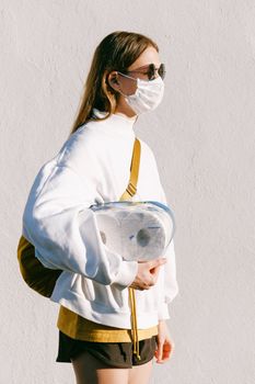 白天，一名戴口罩的妇女在户外拿着卫生纸