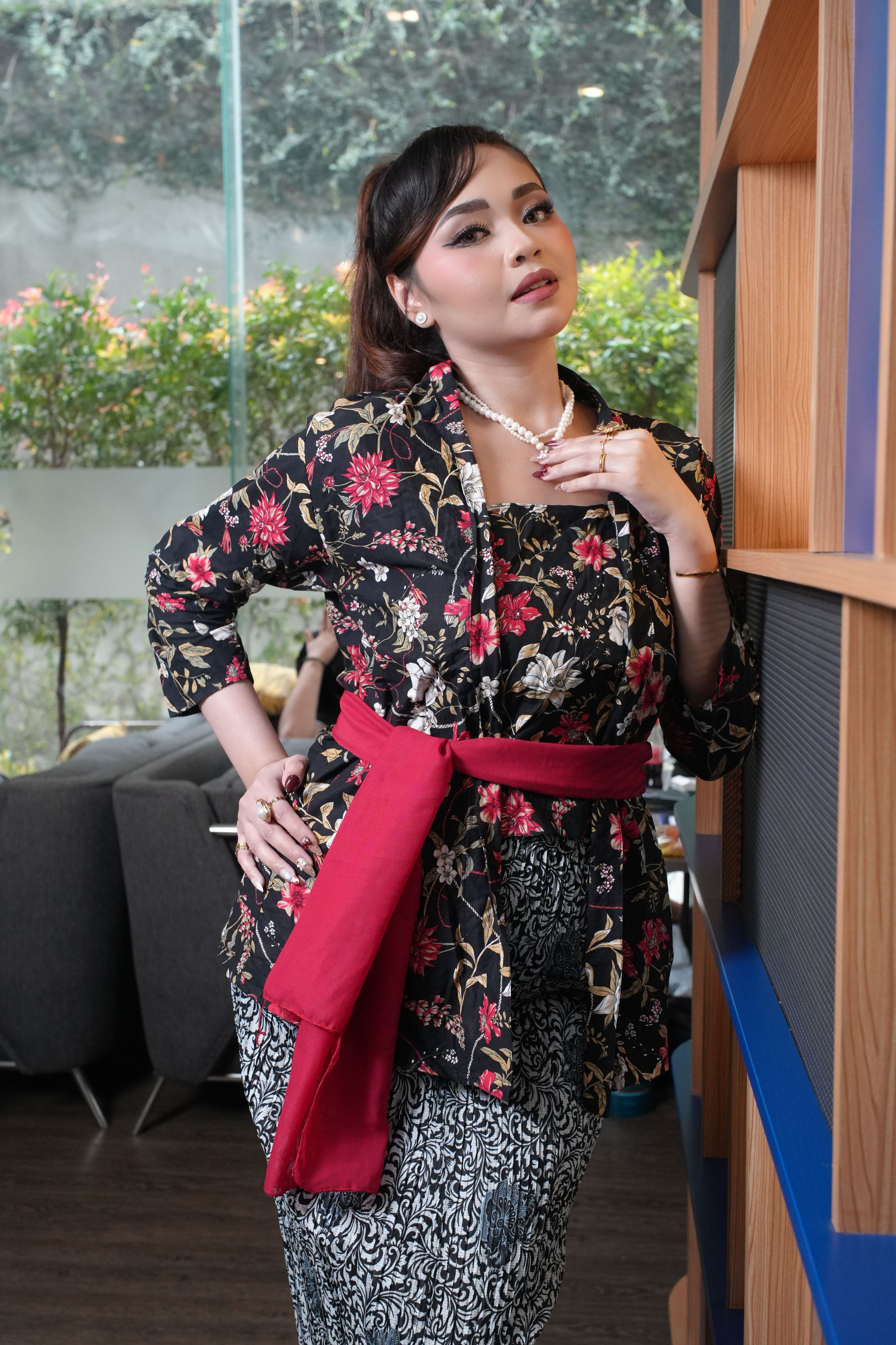 Stylish woman wearing a Batik dress indoors in Jakarta, Indonesia.