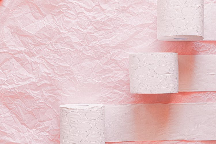 White Toilet Paper Roll On Pink Textile