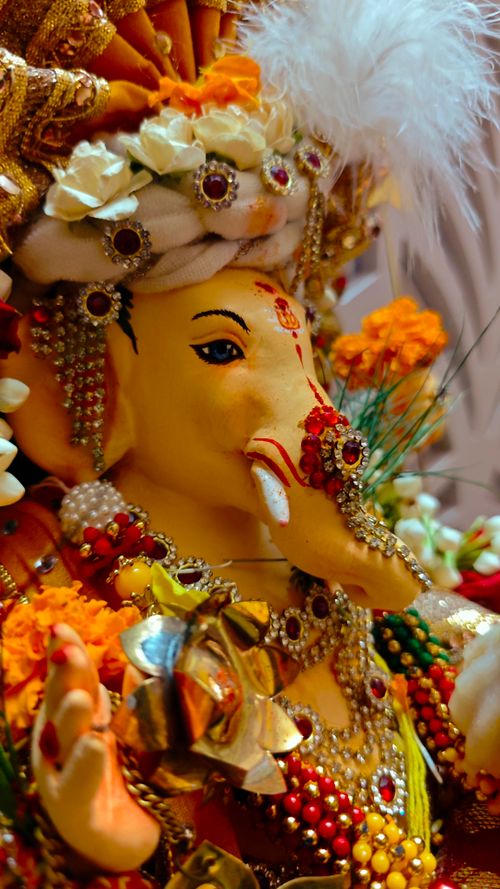 Free Close-up of a vibrant Ganesha idol adorned with jewels and flowers, symbolizing Hindu spirituality. Stock Photo