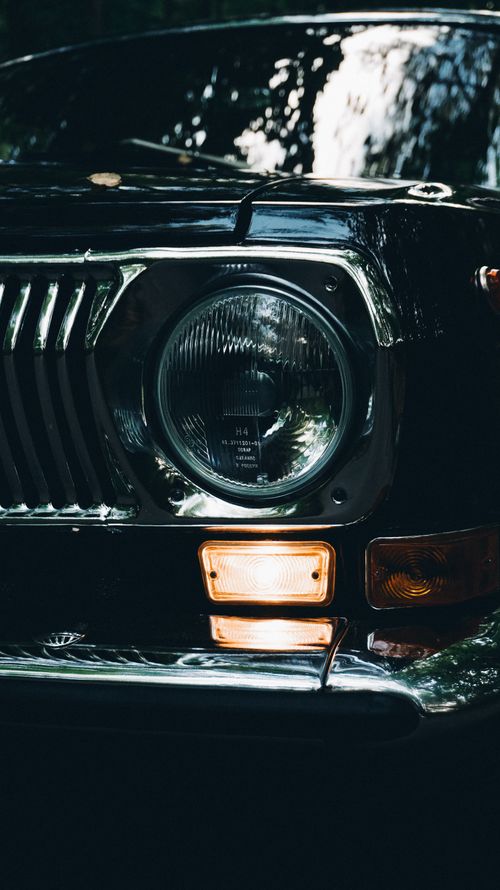 Free Moody close-up of a vintage car headlight with reflection details. Stock Photo