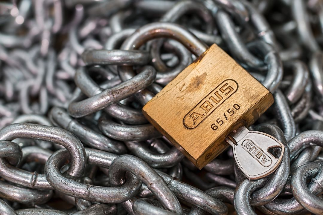 Website Security and Backups: Why They Matter More Than You Think 1 A detailed macro shot of a brass padlock with a key on heavy steel chains, symbolizing security and protection.
