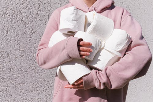 Free Woman in Pink Long Sleeve Hoodie Carrying Tissue Rolls Stock Photo