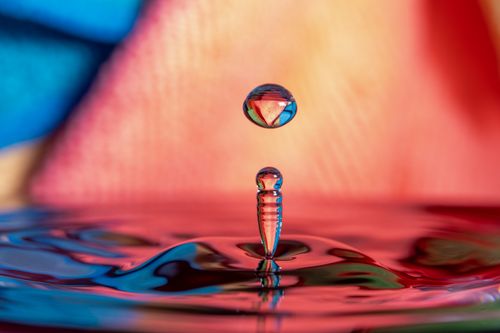 Free Colorful high-speed photograph of a water drop splash with vibrant reflections and refractions. Stock Photo