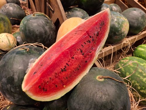 Free Vibrant sliced watermelon on display at an outdoor market, highlighting freshness and summer vibes. Stock Photo