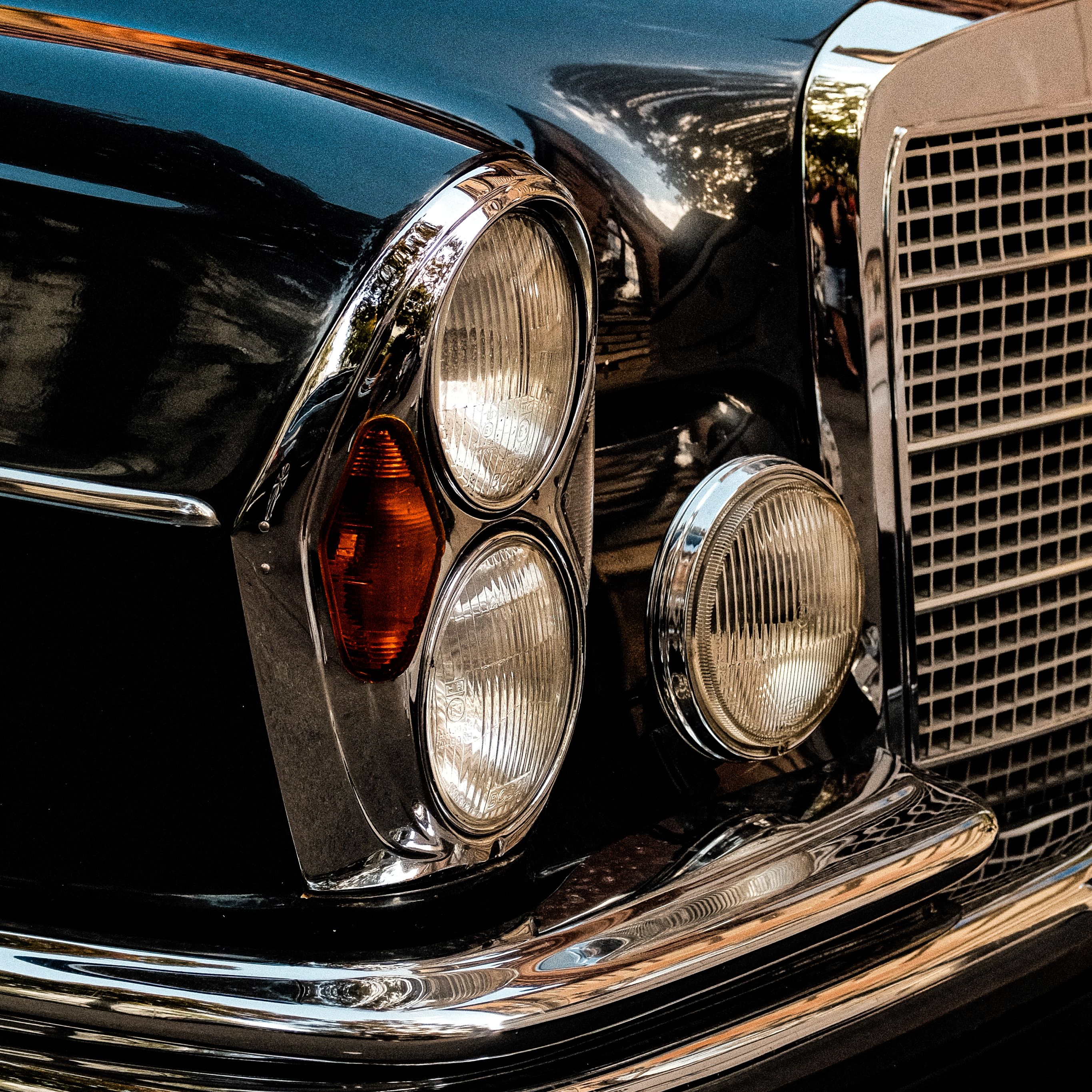 Detailed close-up of a vintage car's headlights and grille in Vienna, Austria.