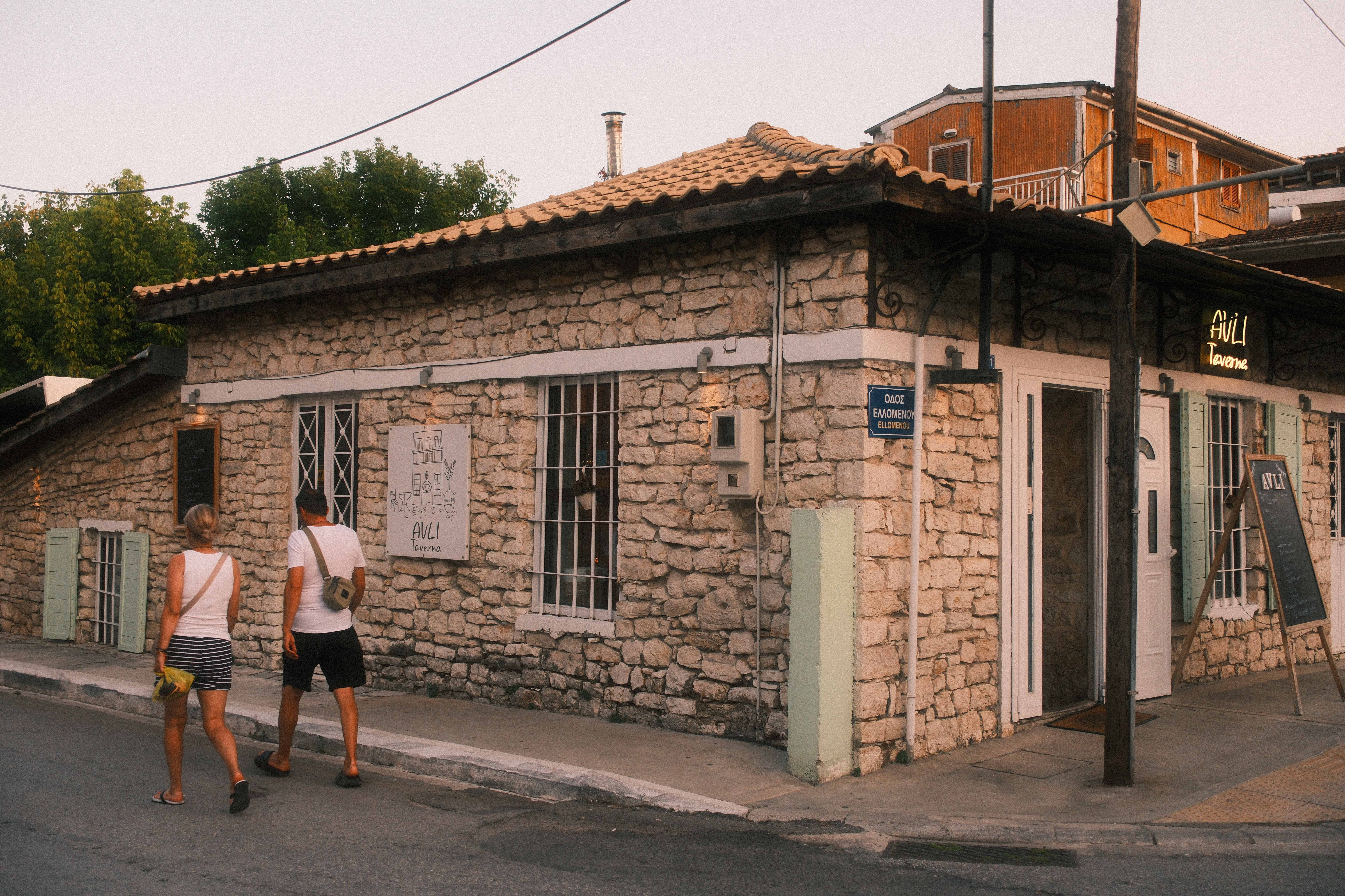 People arriving at a neighborhood restaurant at dusk