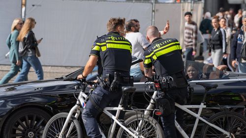 Free Police officers communicate with car passengers in a busy city street. Stock Photo