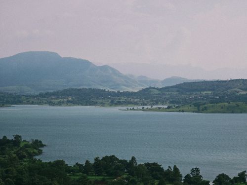 Free Picturesque view of a serene lake with green hills in Pune, India. Stock Photo