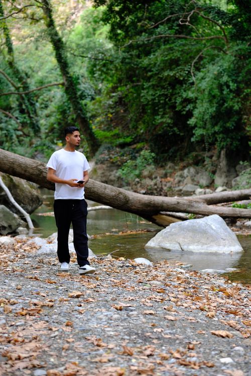 Free A man walks along a tranquil riverbank in the lush forests of Bursa, Türkiye. Stock Photo