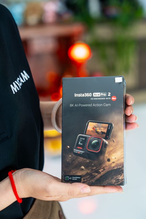 Free Person holding Insta360 Ace Pro 2 in a store setting, eye-catching display. Stock Photo
