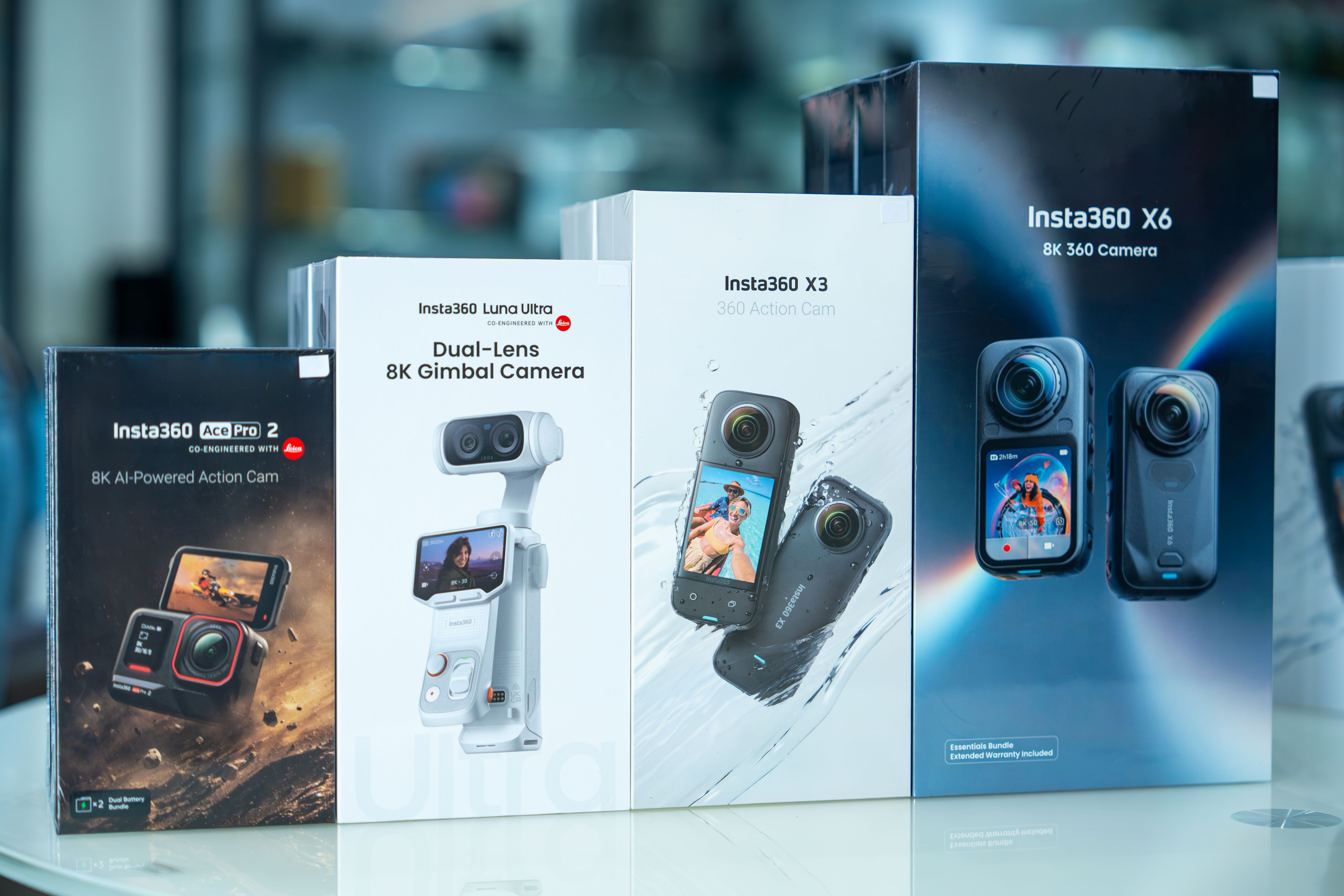 Insta360 camera packaging featuring various models displayed on a reflective surface.