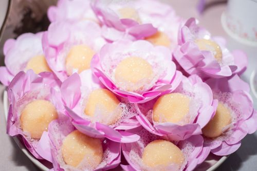 Free Sweet confections artfully arranged in pink flower-like wrappers, ready for a celebration. Stock Photo