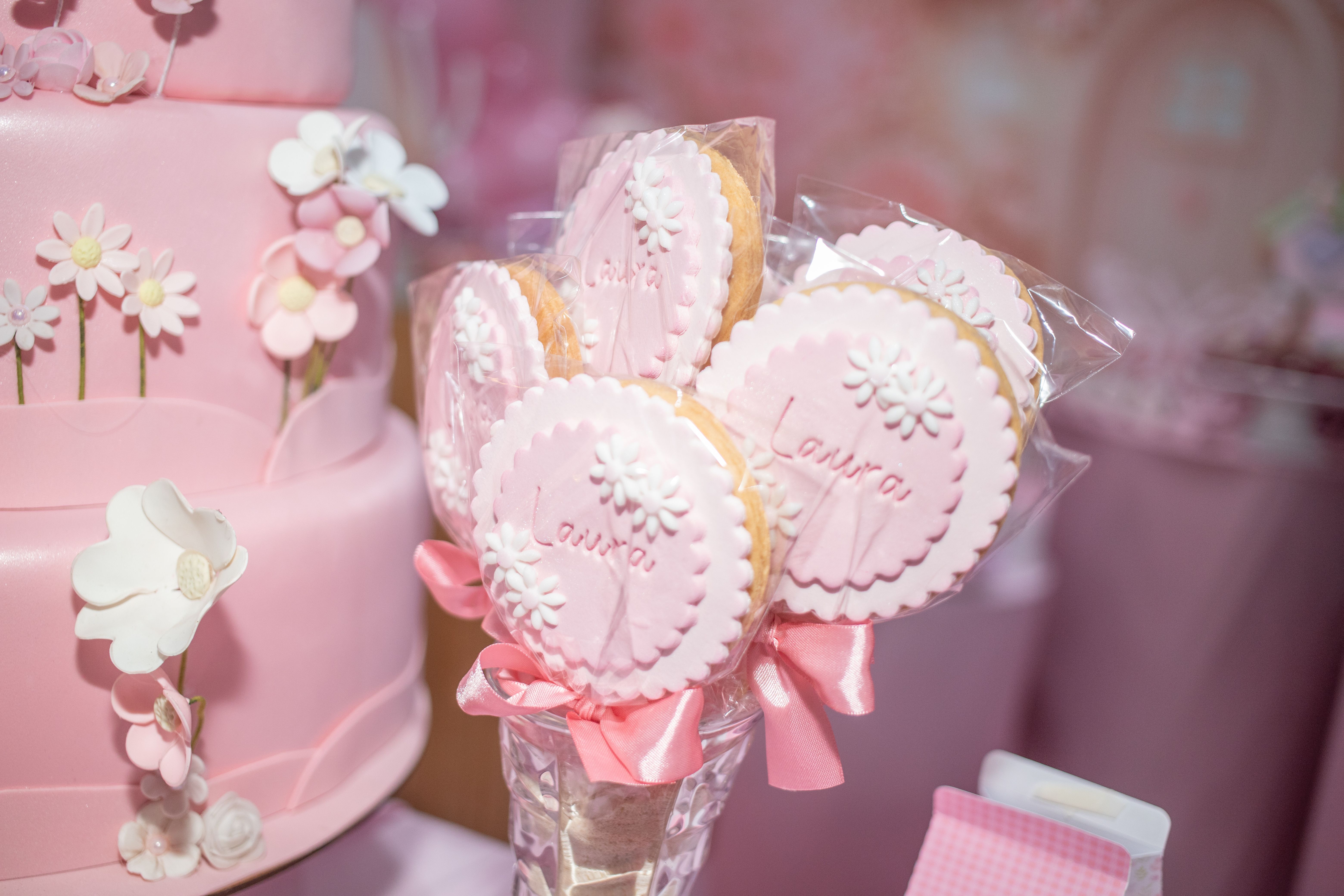 Charming pink floral cake with personalized name cookies, perfect for a special occasion.