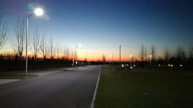 暮光天空充满活力，街景安静，配有灯柱，非常适合旅行和自然主题
