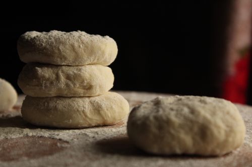Free Flour-dusted dough pieces stacked and ready for baking, conveying homemade freshness. Stock Photo