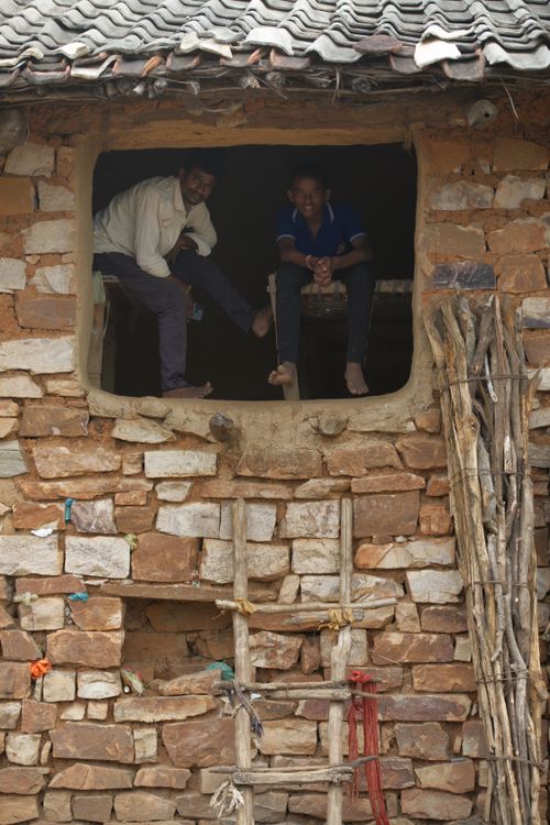 Free Two villagers sitting inside a rustic stone house in Naimisharanya, capturing rural life in India. Stock Photo