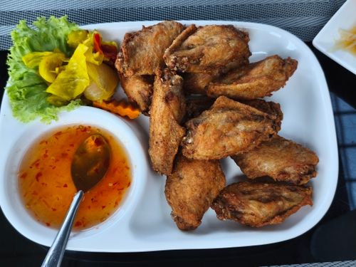 Free Plate of crispy fried chicken wings with dipping sauce and salad garnish. Stock Photo