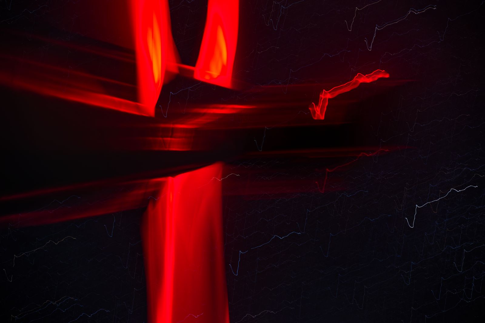 Traînées de néon rouge abstraites formant une croix lumineuse