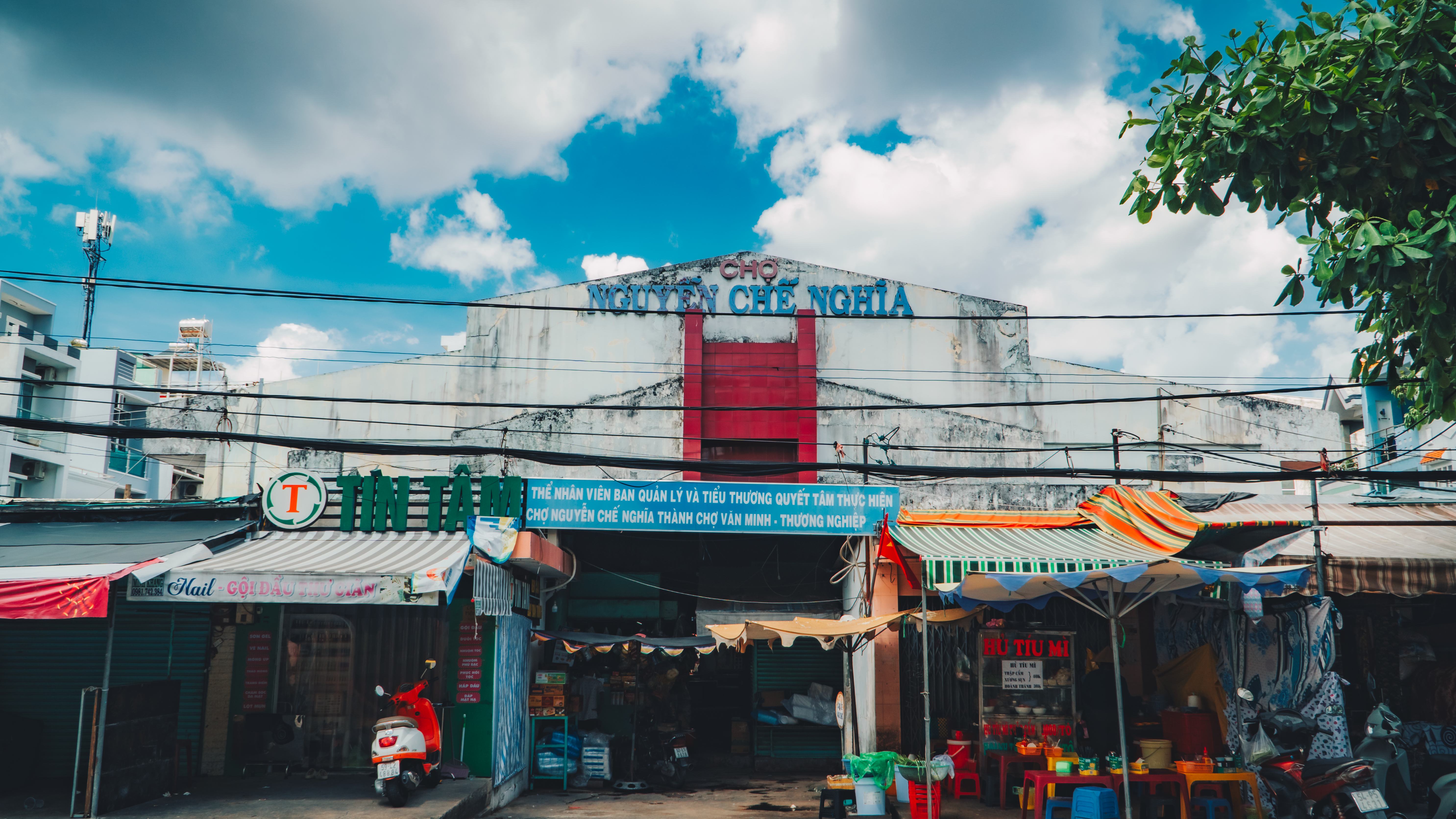 Front view of a vibrant market in Vietnam showcasing colorful storefronts under a bright sky.