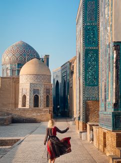 Free A woman walks along the ancient Shah-i-Zinda necropolis in Samarqand, showcasing stunning Islamic architecture. Stock Photo