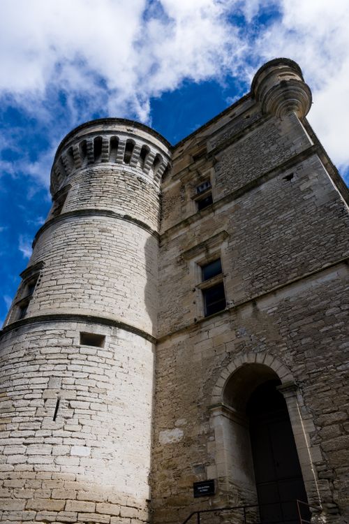 Free Ancient stone castle tower in France set against a vibrant blue sky, adding historical charm. Stock Photo