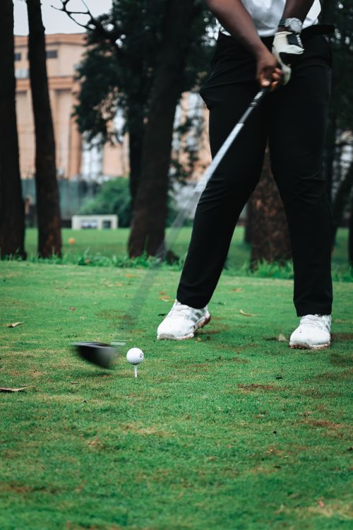 Free Close-up of a golfer mid-swing on a vibrant green course, capturing the dynamic energy of the sport. Stock Photo