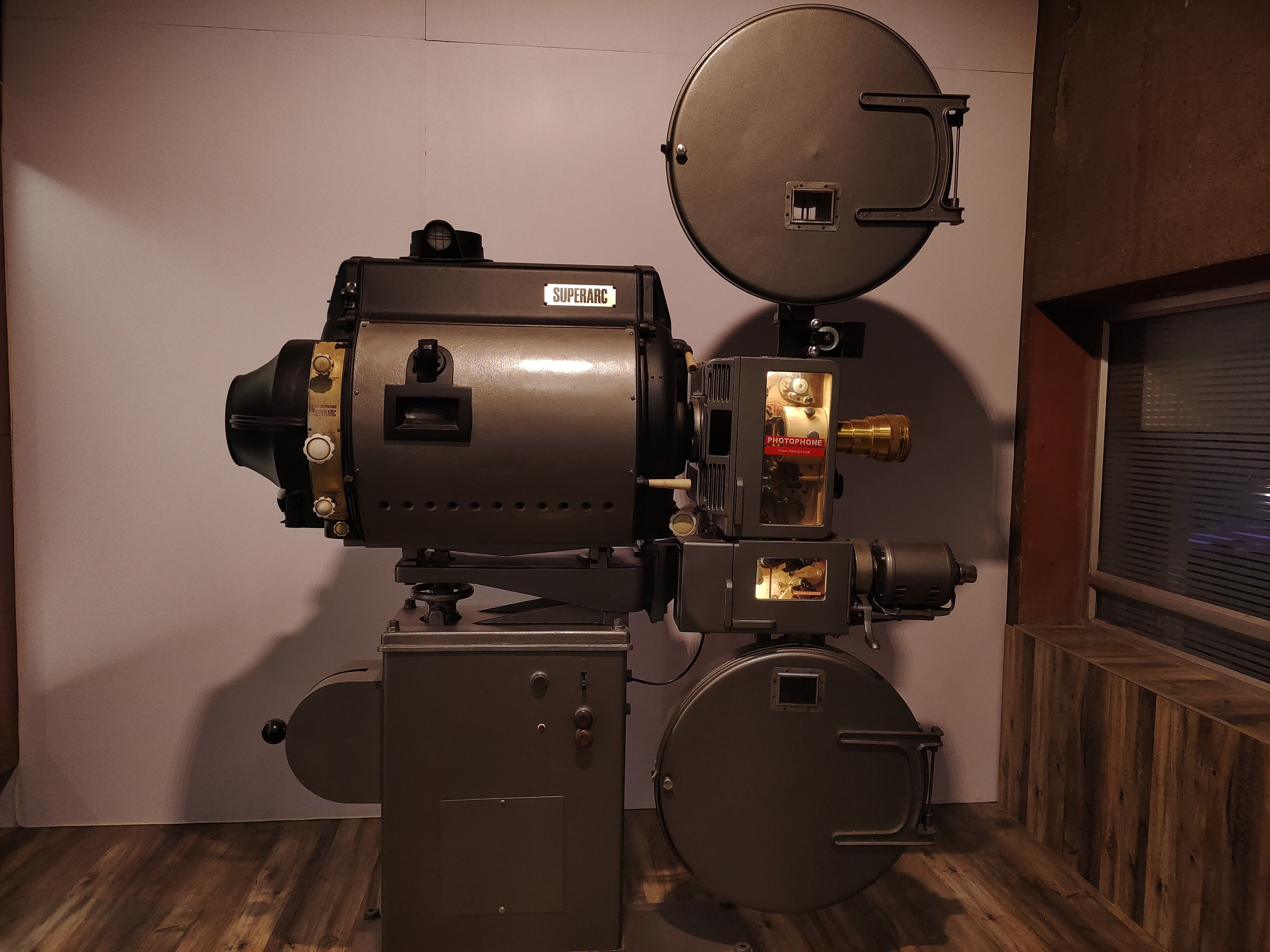 Old-fashioned Superarc film projector displayed indoors, evoking cinematic history.