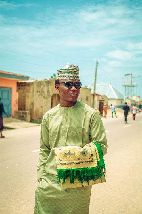 Free A man in traditional Nigerian attire smiling outdoors with clear blue skies. Stock Photo
