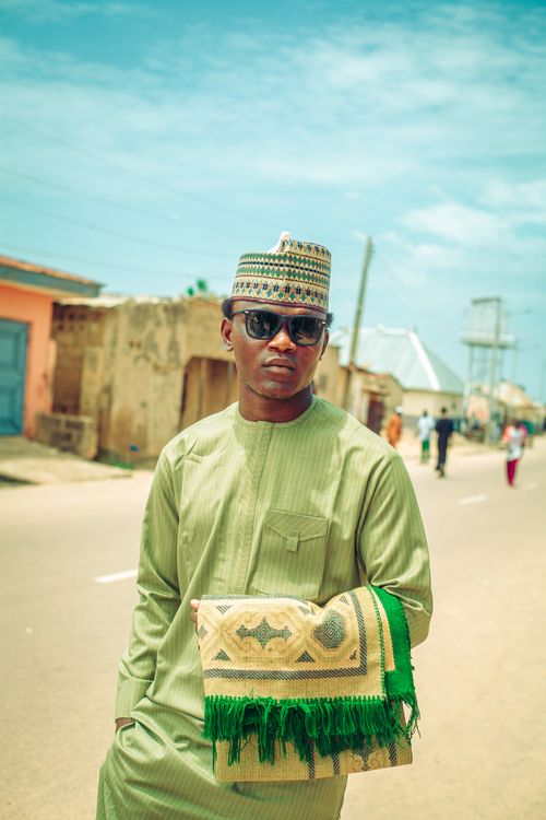 Free Stylish young man wearing traditional attire on a sunny day in an urban setting. Stock Photo