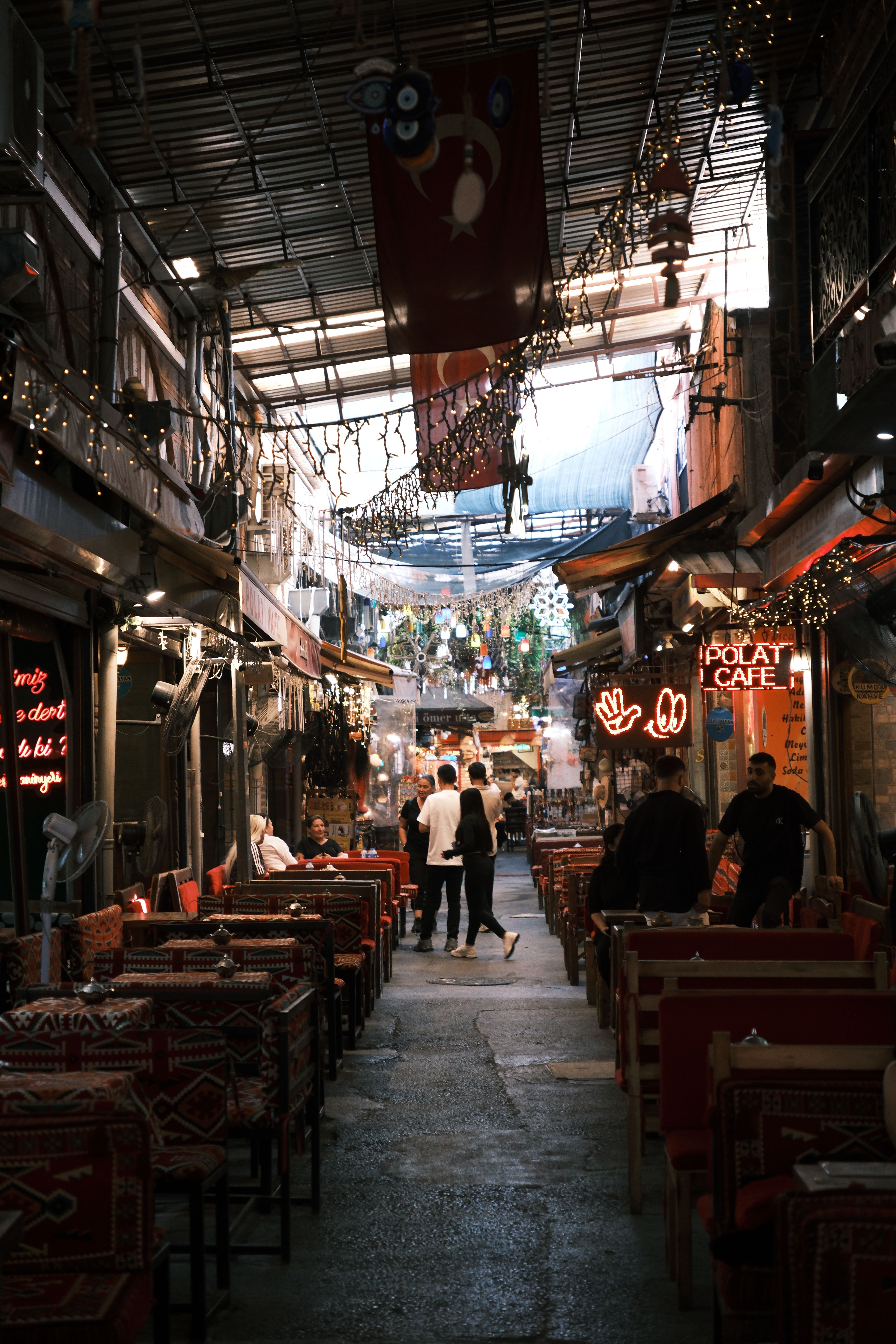 Explore Izmir's lively cafes in a bustling alleyway, capturing the city's vibrant nightlife.