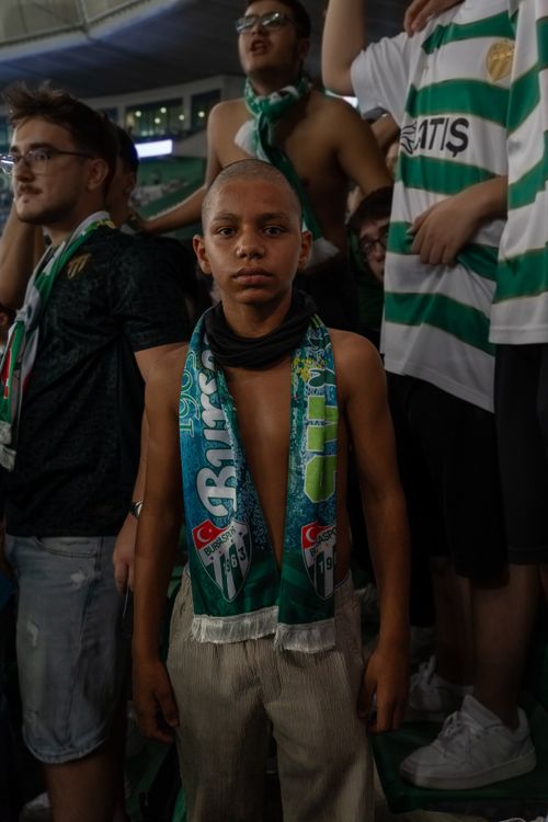 Free Excited young soccer fan wearing team scarf during a lively match at the stadium. Stock Photo