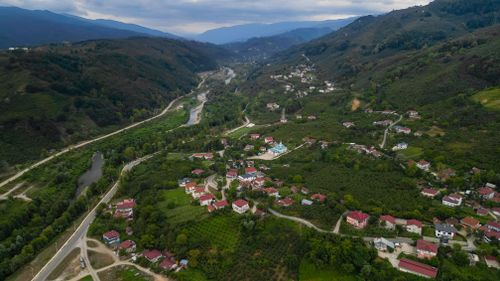 Free Aerial view of a beautiful village nestled in lush green mountains in Turkey. Stock Photo
