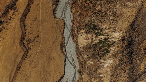 Free Aerial shot of a dry riverbed with contrasting landscapes in New Zealand. Stock Photo
