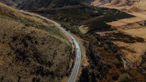 Free Aerial photograph capturing the winding road through New Zealand's picturesque countryside landscape during a serene day. Stock Photo