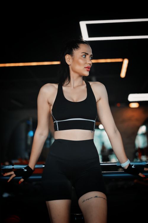 Free Woman in athletic wear exercising in a gym with contemporary lighting. Stock Photo