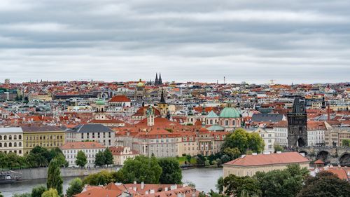 Free Aerial view of Prague showcasing historic architecture and Charles Bridge under cloudy skies. Stock Photo