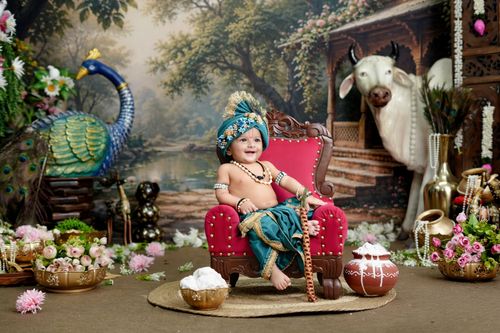 Free Charming baby dressed as Krishna in a vibrant traditional setting with peacock and cow decor. Stock Photo