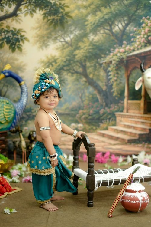 Free A charming child dressed in vibrant traditional Indian attire in a lush, scenic setting. Stock Photo