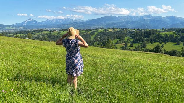 Woman enjoys the picturesque view of the Tatra Mountains in Poland during summer.