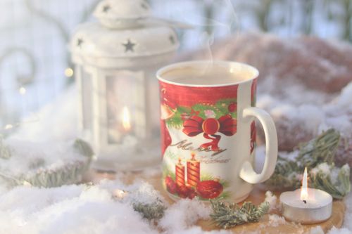 Free Warm Christmas mug and lantern in a snowy winter setting, creating a cozy seasonal vibe. Stock Photo
