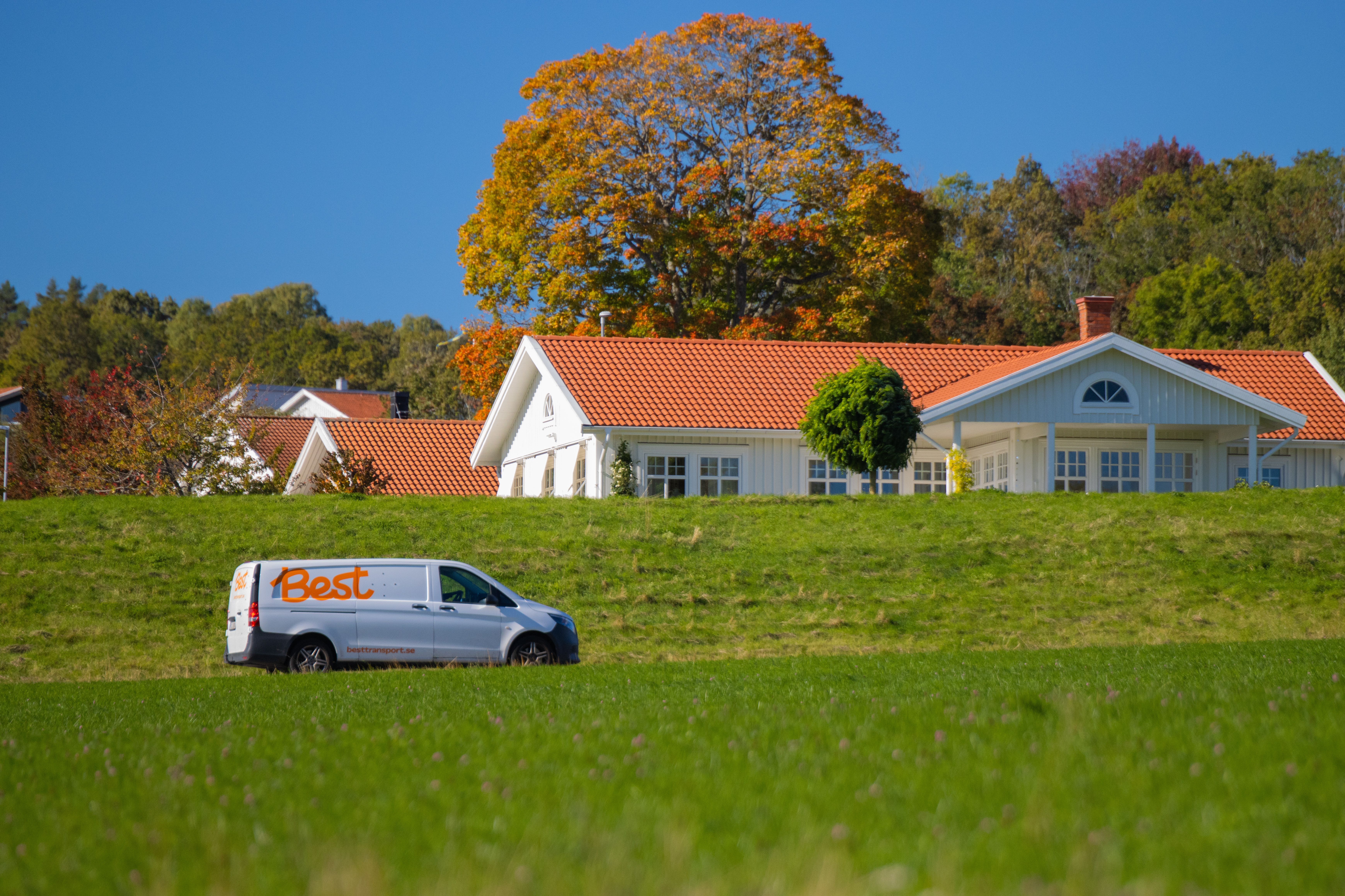Scenic view of a countryside house with a delivery van in Jönköping, capturing autumn colors.